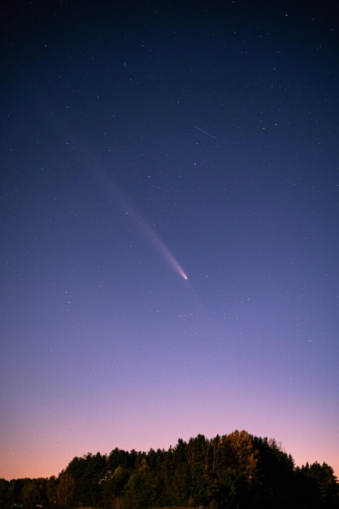pexels-photo-28973934-28973934 Beautiful night sky view with a comet and twinkling stars over a forest silhouette.