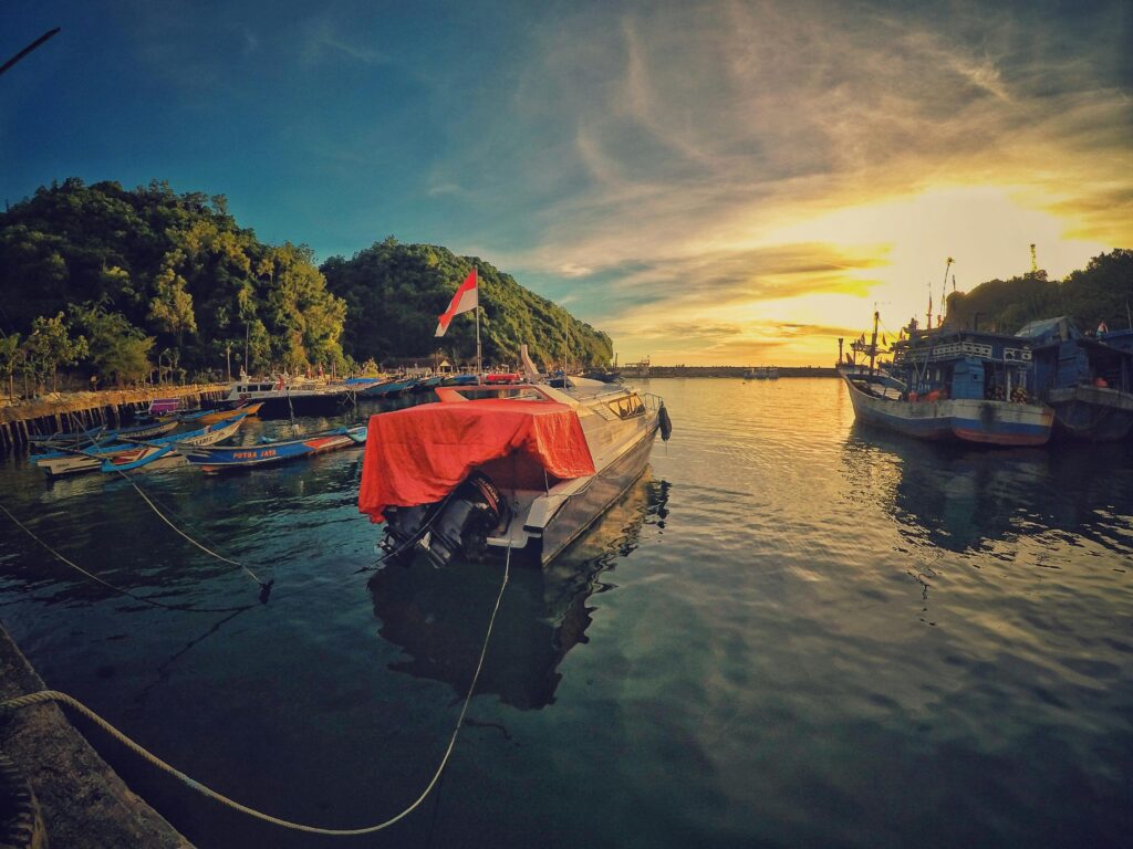 pexels-photo-758742-758742 A stunning sunset view at Girisubo Harbor, Indonesia, with boats and lush hills.