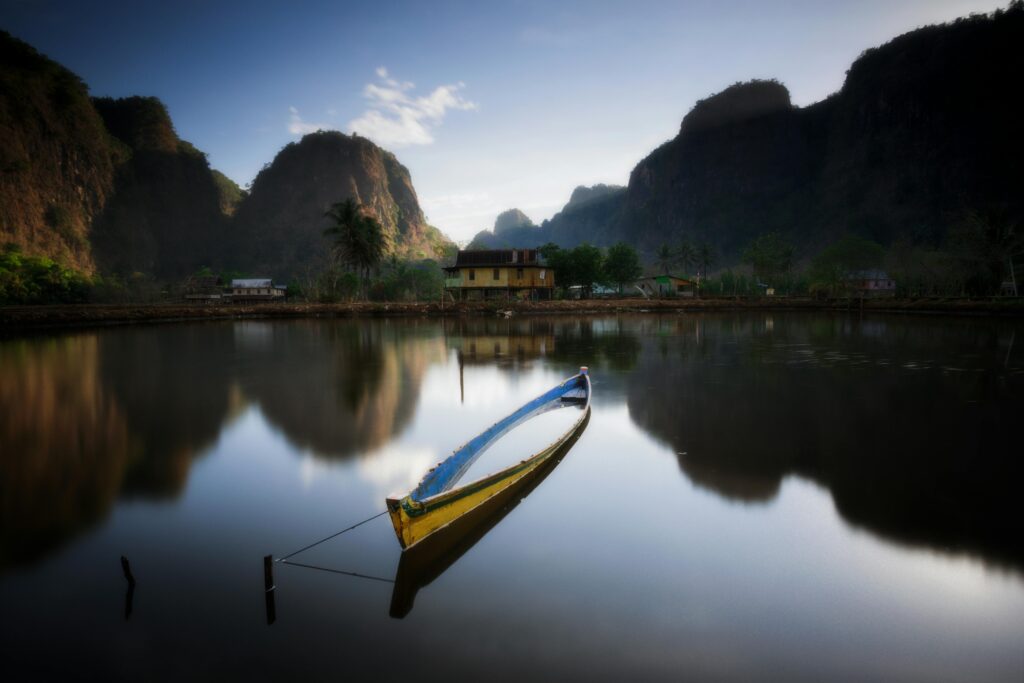 pexels-photo-7120751-7120751 Tranquil scene of a traditional boat on a calm lake in South Sulawesi, Indonesia.